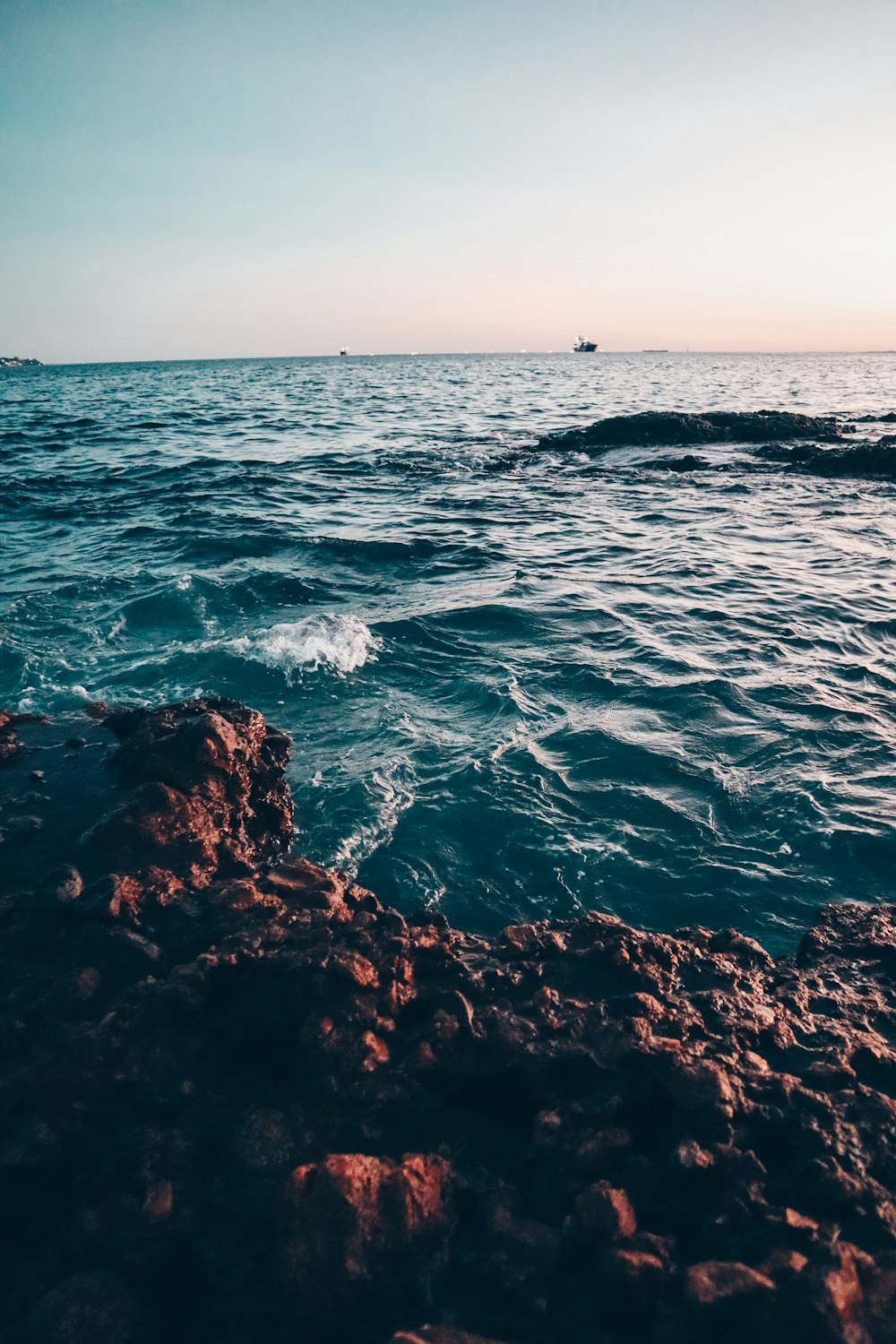 ocean waves crashing on brown rocks during daytime