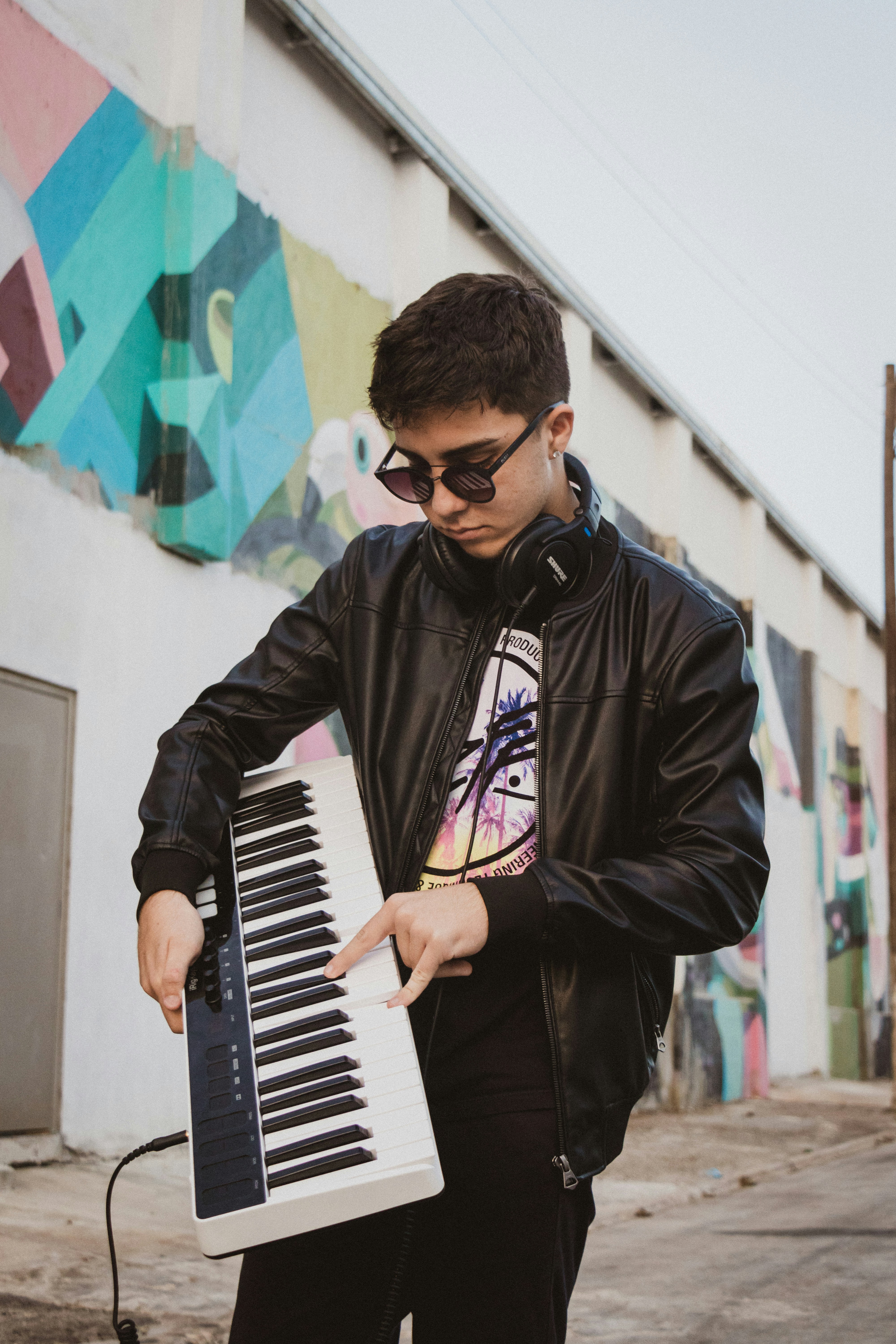 man in black leather jacket playing piano