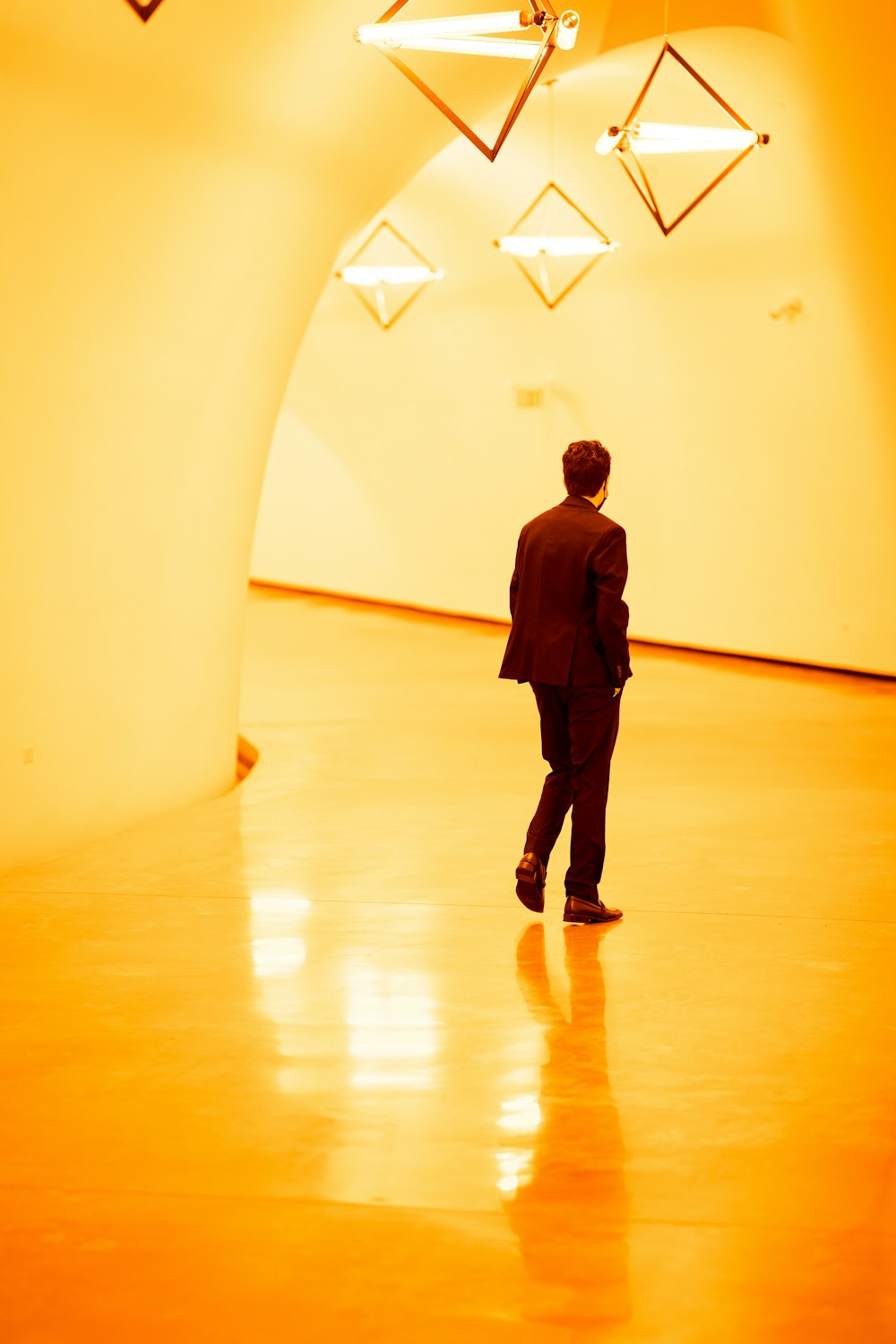 man in black jacket walking on brown wooden floor