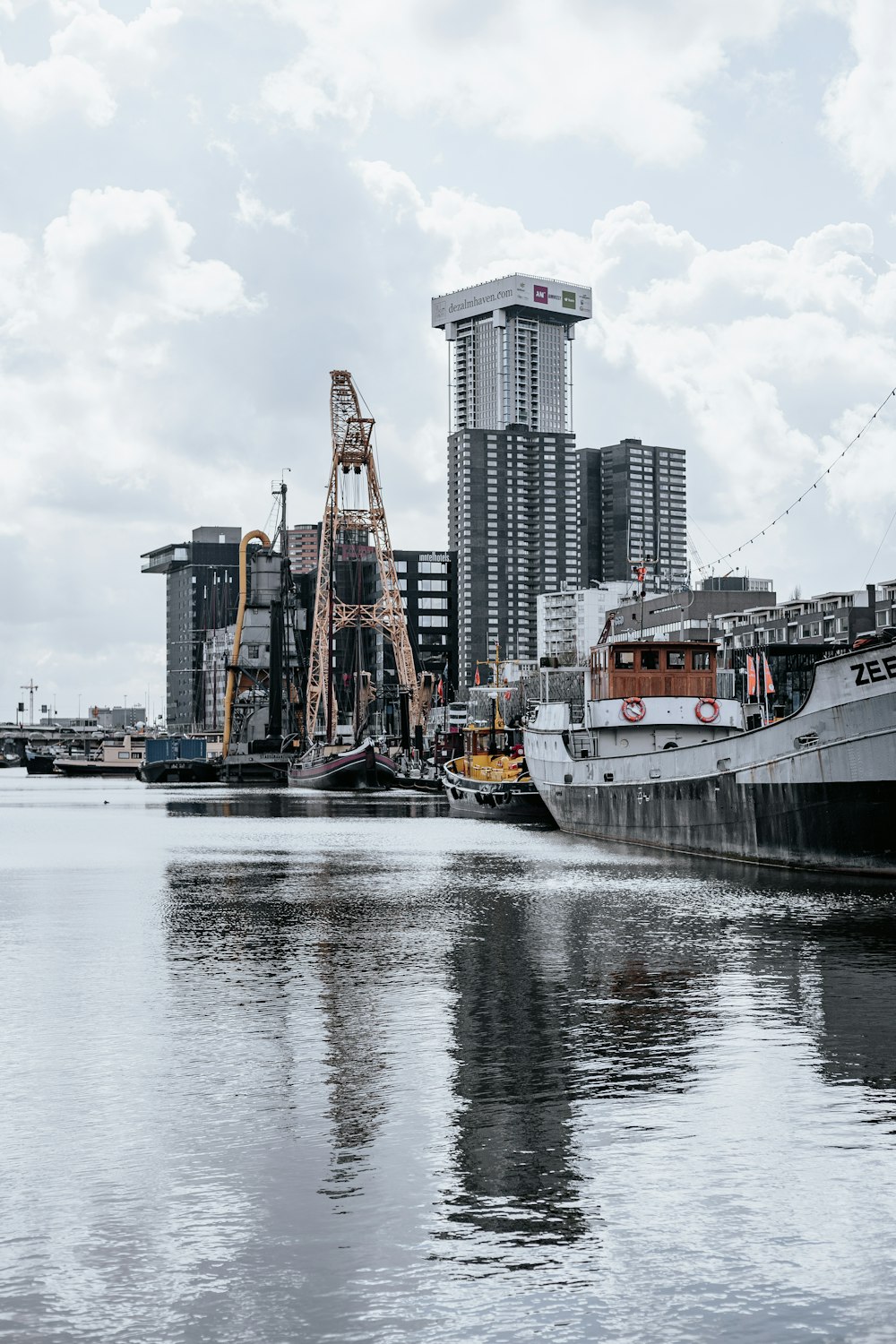 Navire blanc et noir sur l’eau près des bâtiments de la ville pendant la journée