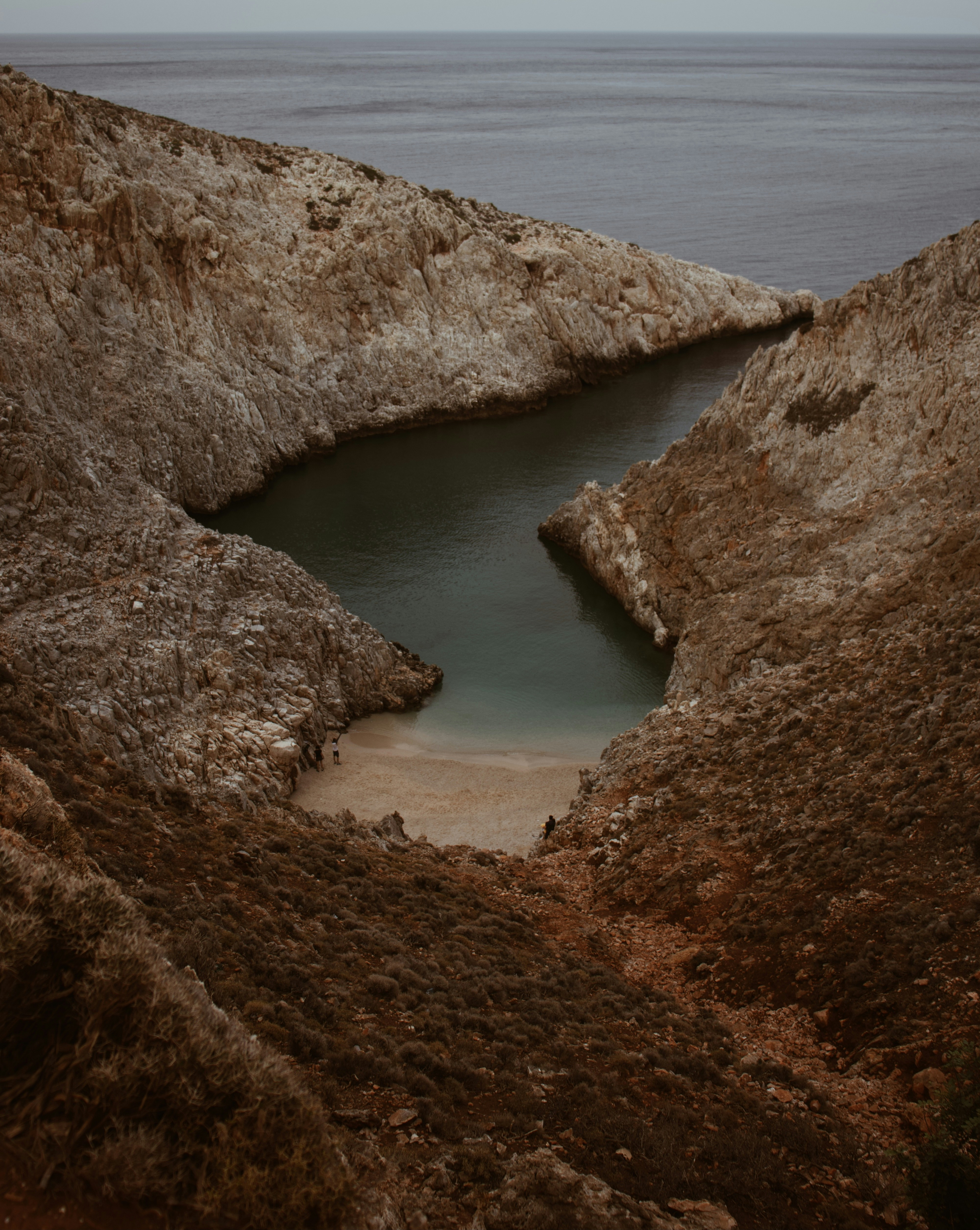 brown rock formation near body of water during daytime