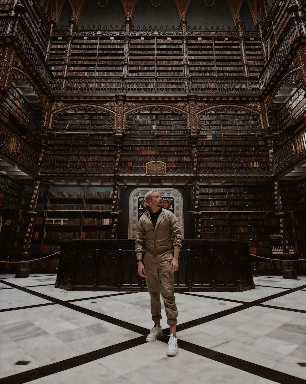 man in brown suit standing on white floor tiles