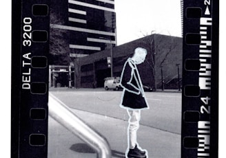 woman in black and white dress walking on sidewalk during daytime