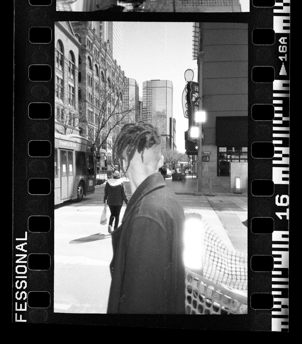 grayscale photo of man and woman walking on street