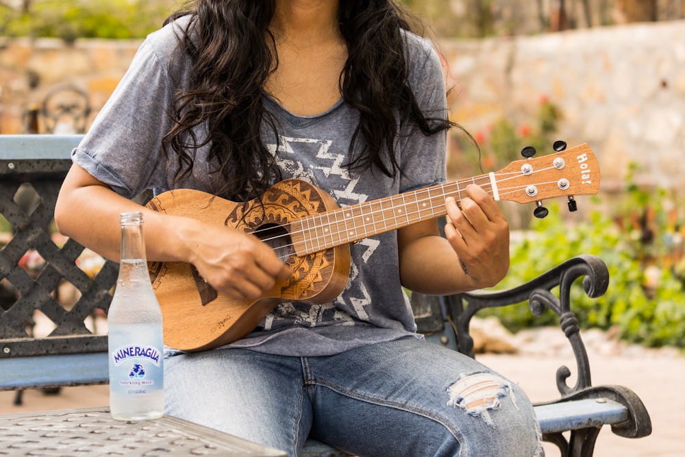 woman in brown long sleeve shirt playing acoustic guitar