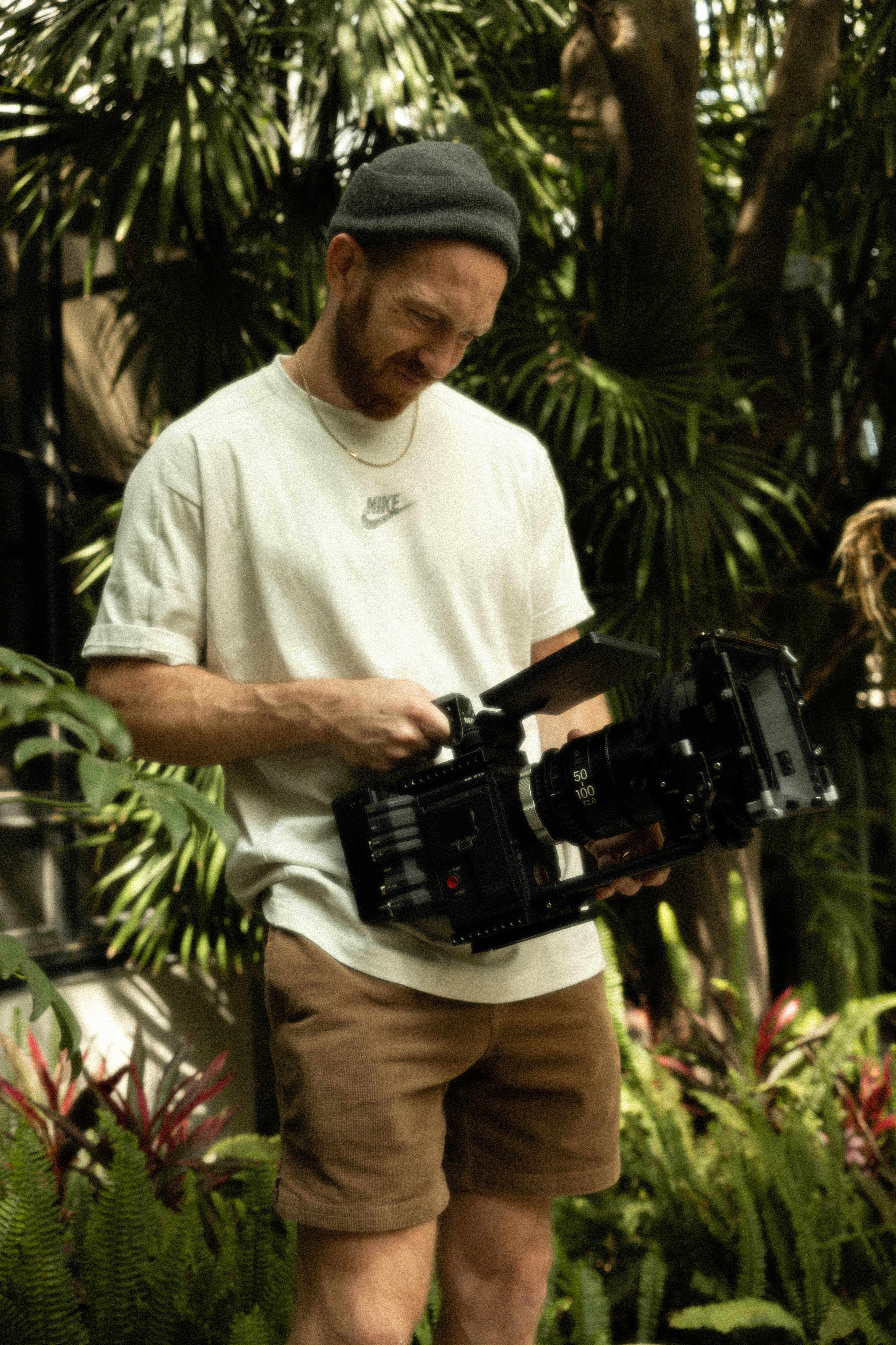 man in white polo shirt holding black dslr camera