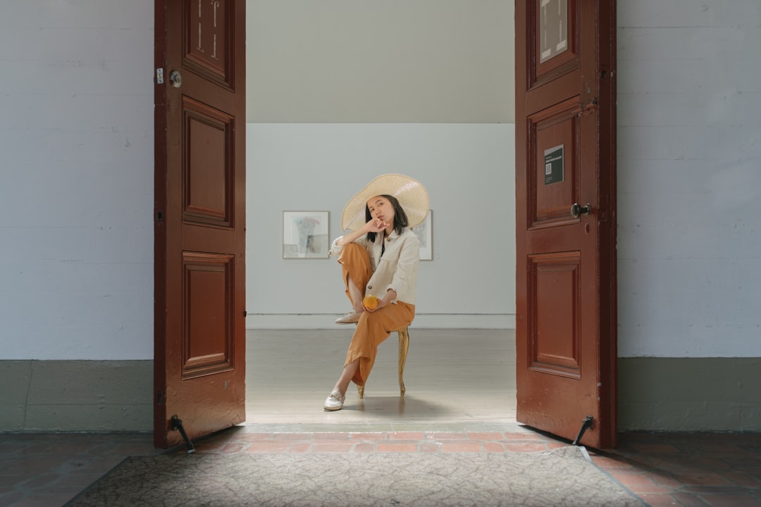 woman in white long sleeve shirt and brown skirt standing beside brown wooden door