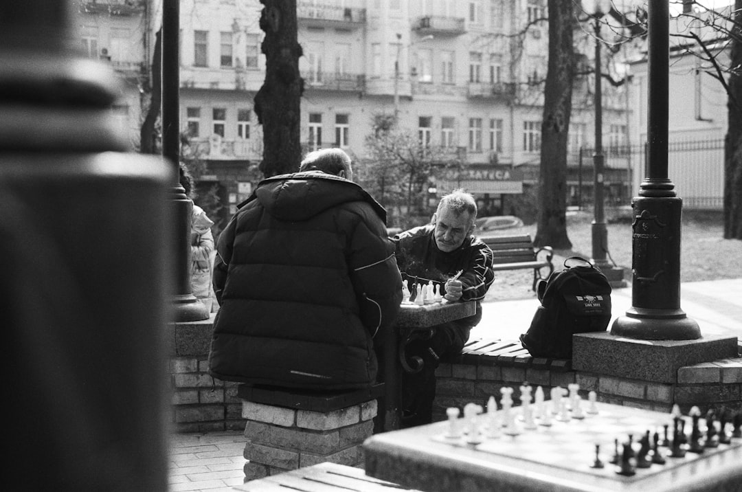 grayscale photo of man and woman sitting on bench