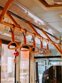 Interior view of a bus showing cushioned seats and handrails, emphasizing comfort and safety.