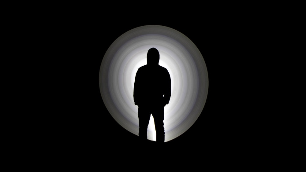 silhouette of man standing on tunnel