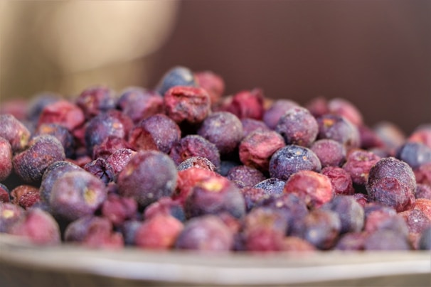Close-up of vibrant, drum-dried organic berry powders in wooden bowls on a rustic table.