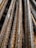 Close-up view of several rusty steel rebar rods stacked together, showing textured surfaces and signs of weathering.