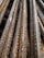 Close-up view of several rusty steel rebar rods stacked together, showing textured surfaces and signs of weathering.