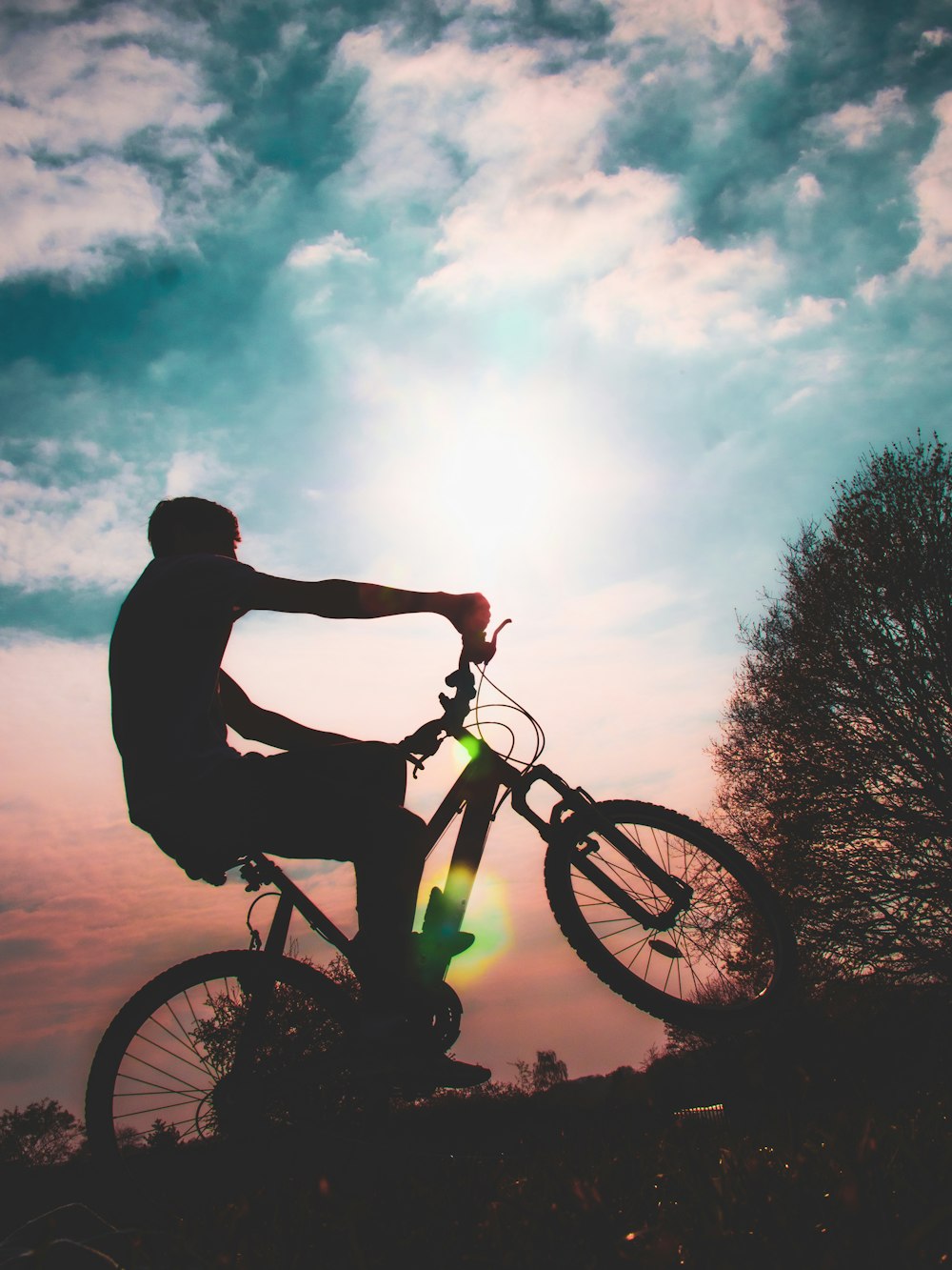silhouette of man riding bicycle during daytime