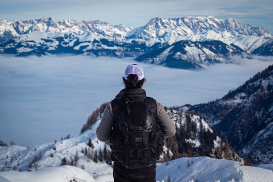 person in black jacket and black pants standing on snow covered ground during daytime in Kaprun Austria