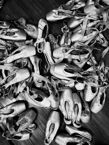 Close-up of worn dance shoes resting on a wooden floor, telling stories of countless nights.