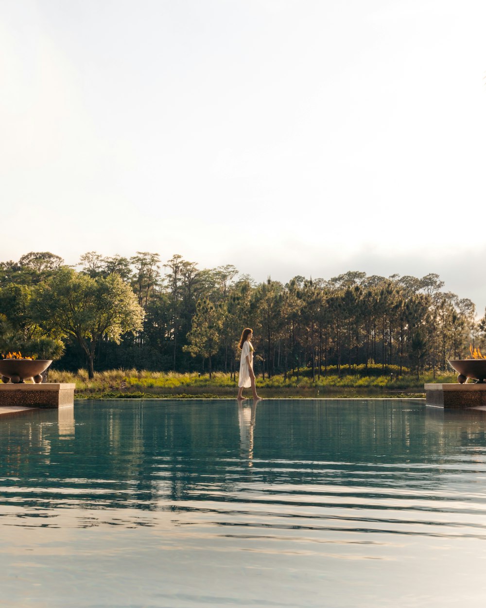 woman in white dress standing on brown wooden dock during daytime