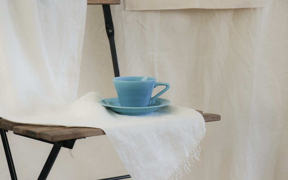 blue ceramic mug on white table cloth