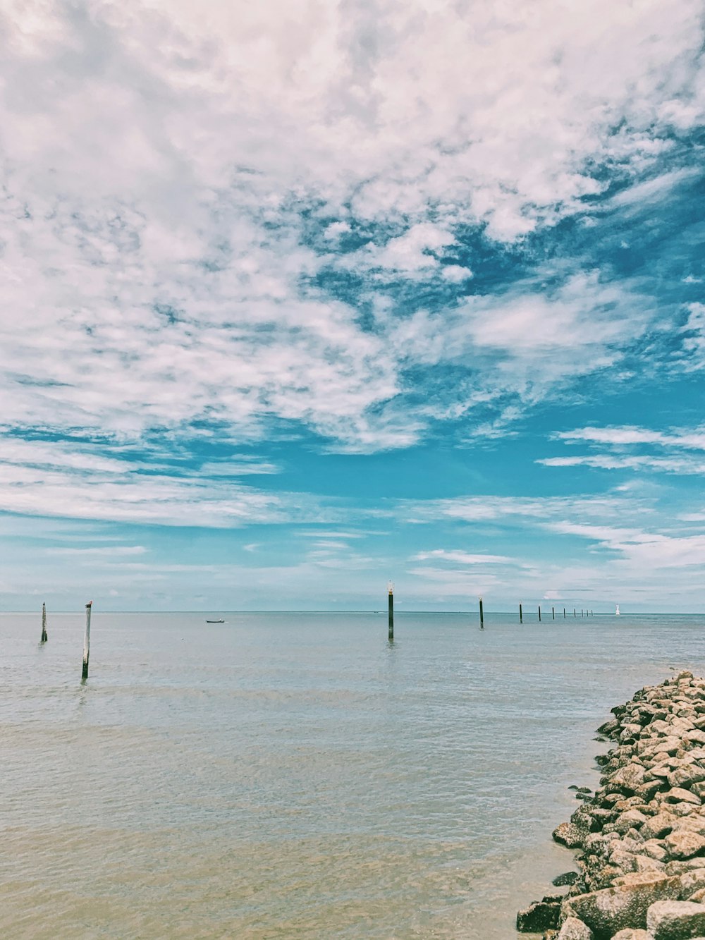 body of water under blue sky and white clouds during daytime