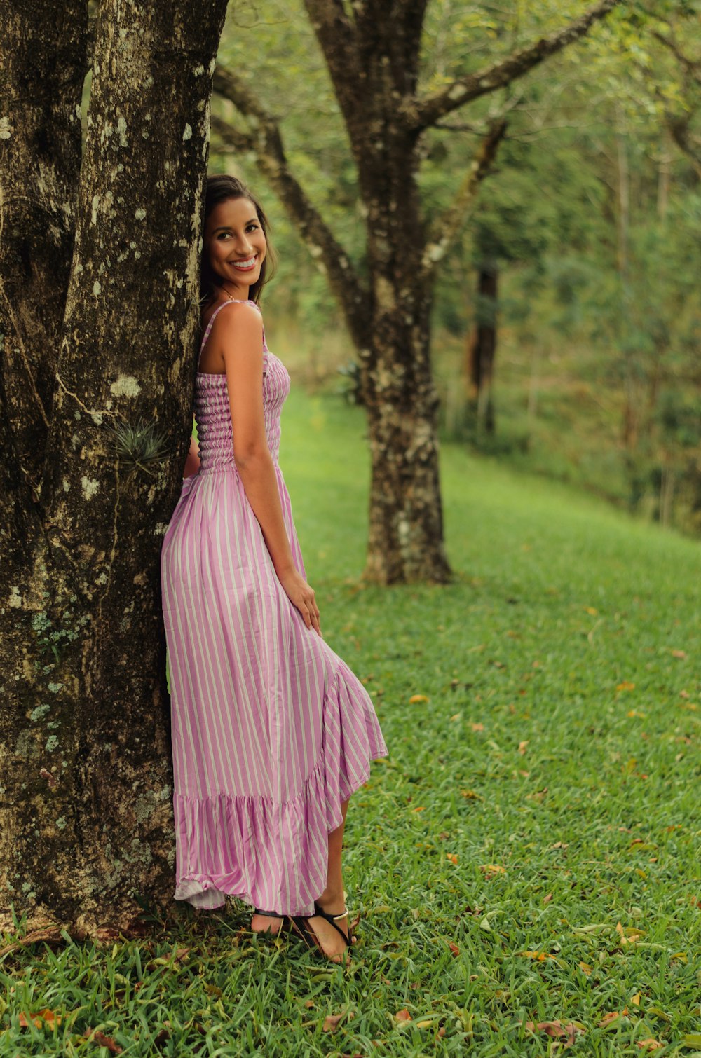 girl in pink dress standing on green grass field
