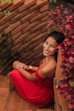 woman in red spaghetti strap dress sitting on brown concrete bench