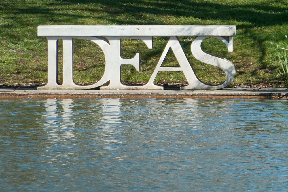 white and black wooden signage on body of water during daytime