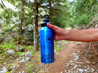 Side view showing the elastic water bottle pocket holding a bottle during a forest hike.