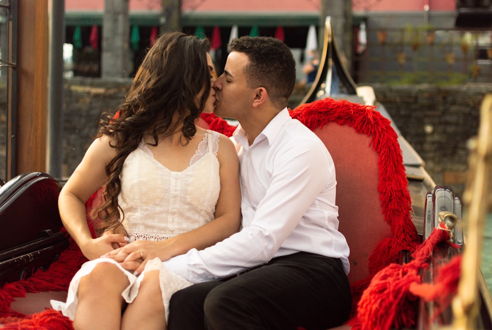 man in white polo shirt sitting beside woman in white sleeveless dress