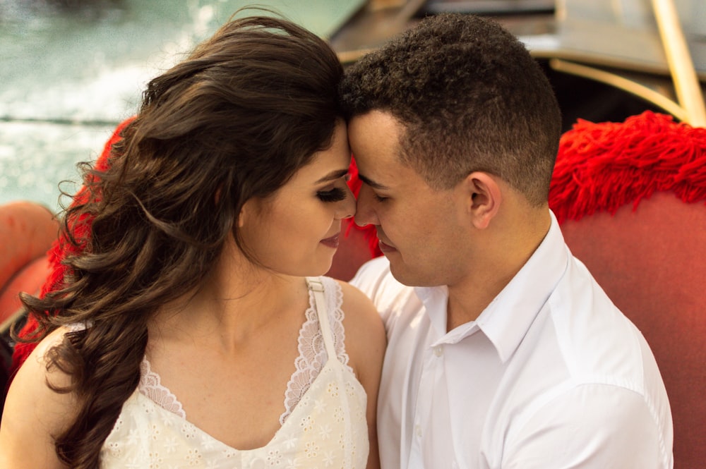 man in white dress shirt kissing woman in white dress