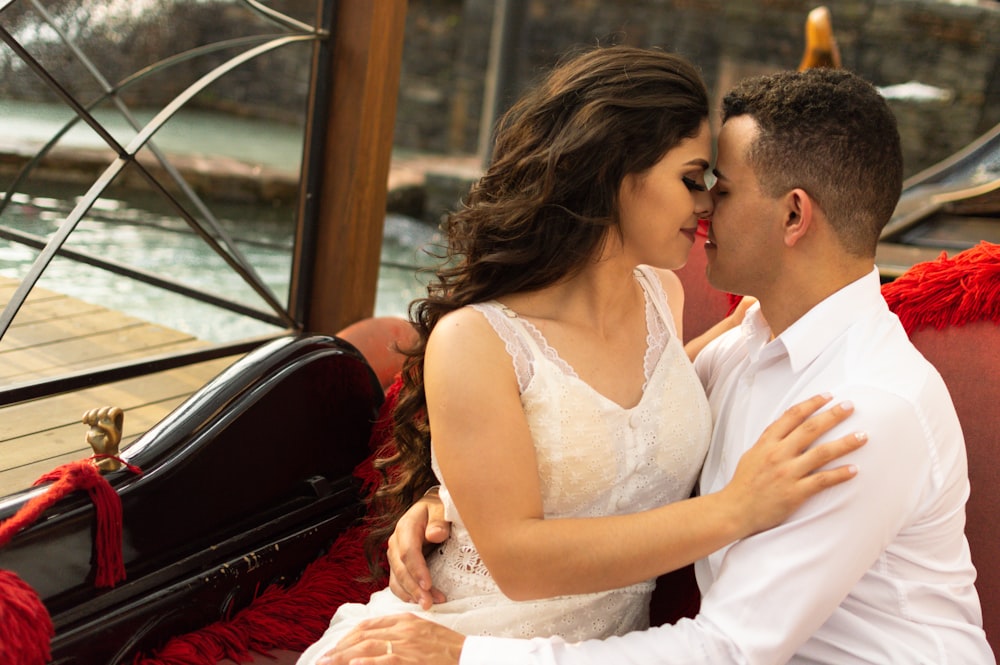 man and woman kissing on brown wooden framed glass window during daytime