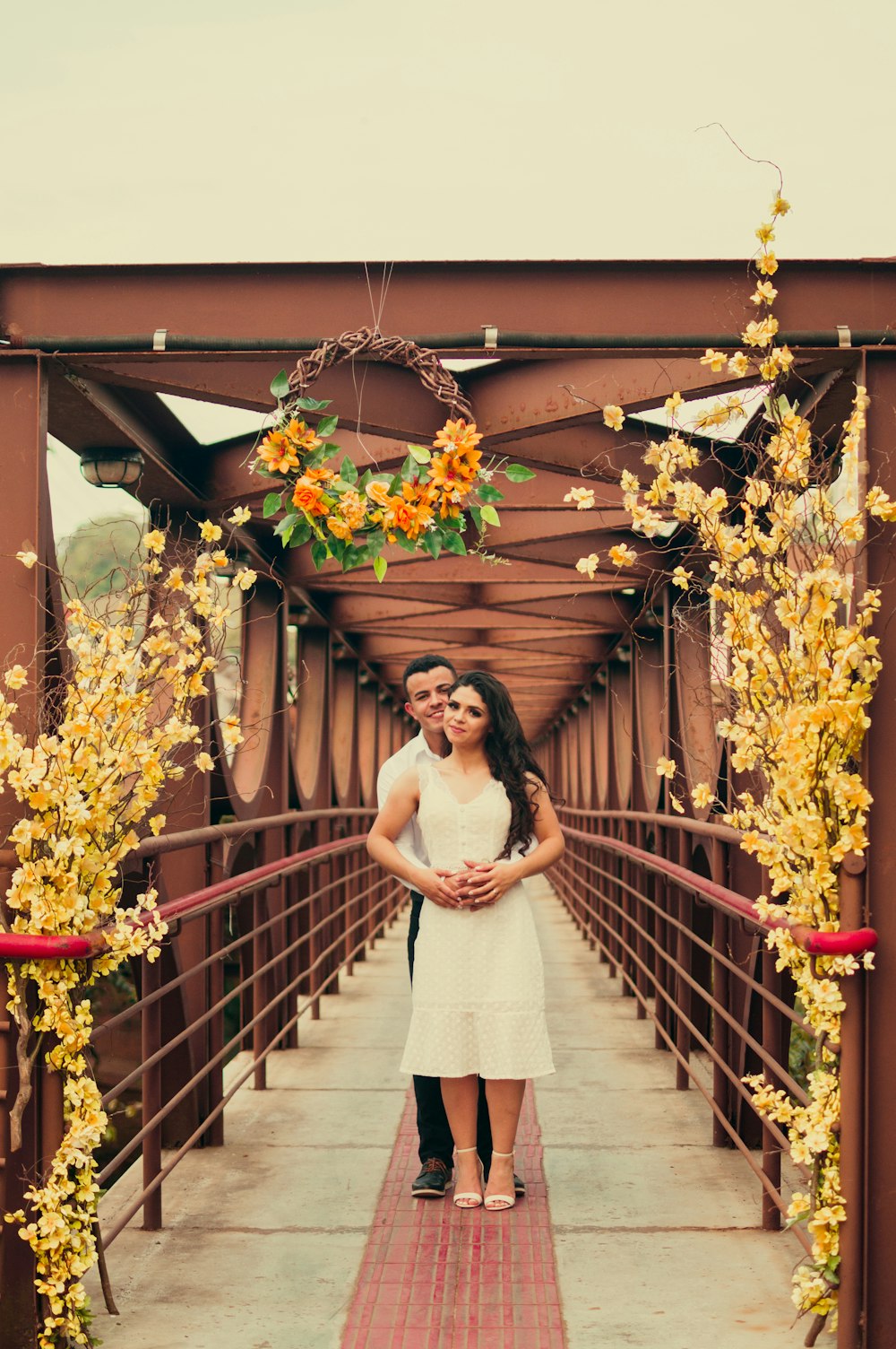 Femme en robe blanche debout sur un pont en bois marron