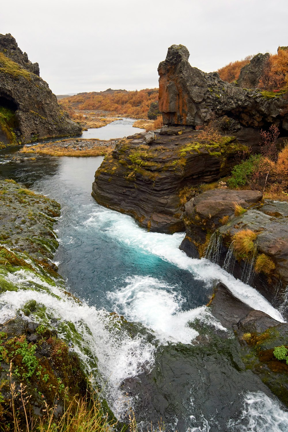 water falls on rocky mountain during daytime