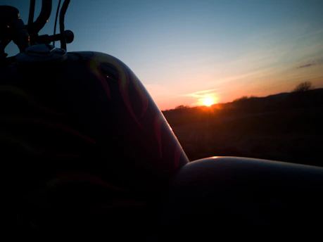 Motorcycle with a custom Suaranusa exhaust roaring on an open road at sunset