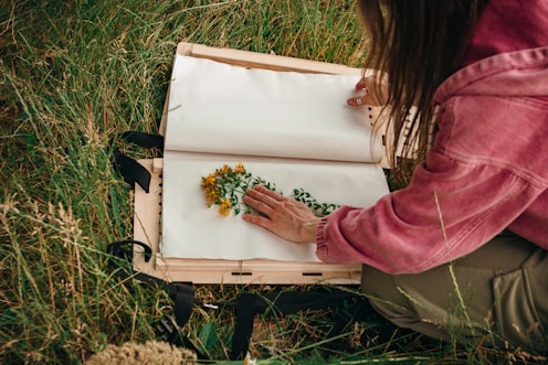 woman in pink long sleeve shirt sitting on white plastic container