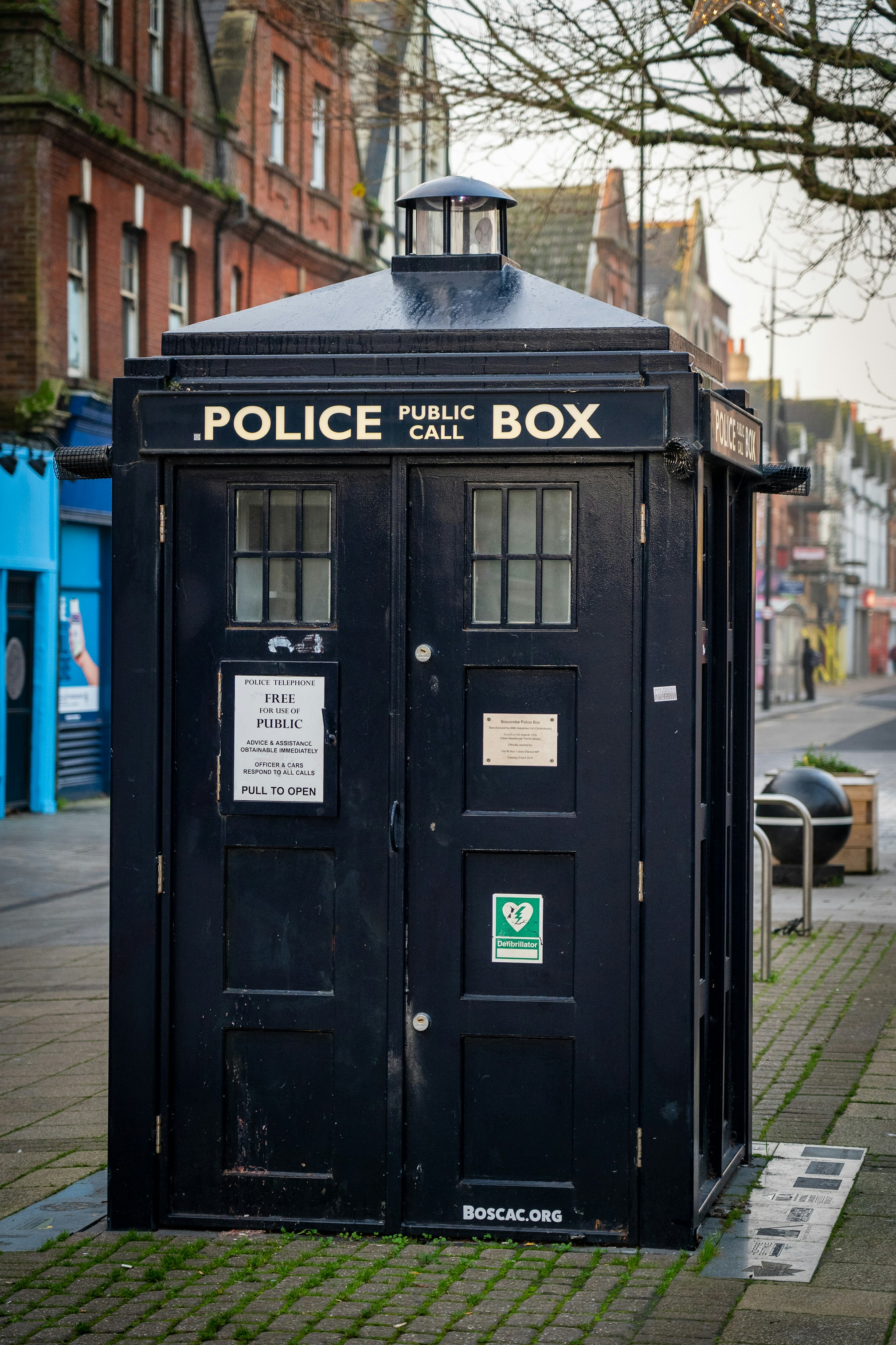 black police box on sidewalk during daytime