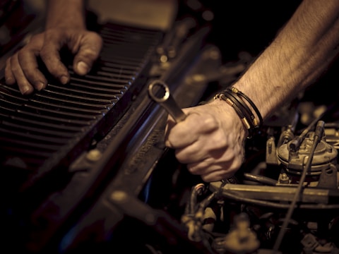 Hands using professional tools to fix a vehicle part
