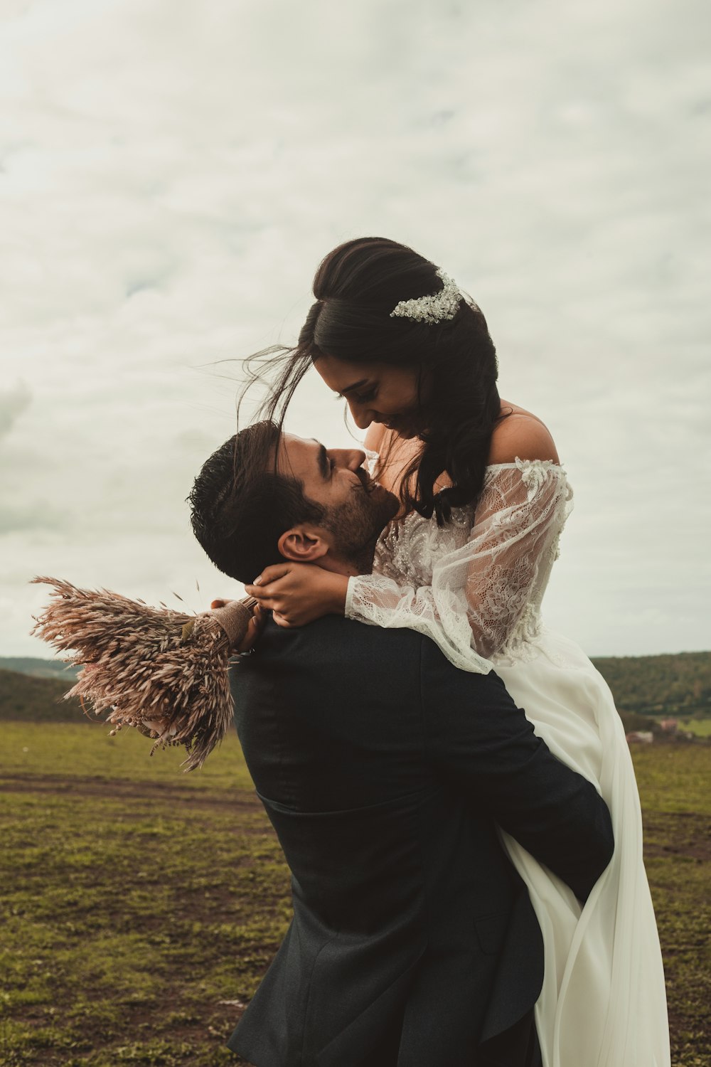 昼間、緑の芝生の上で女性の額にキスをする男