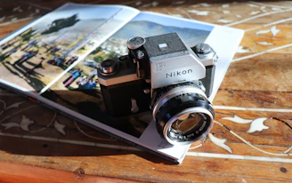 black and silver nikon dslr camera on brown wooden table