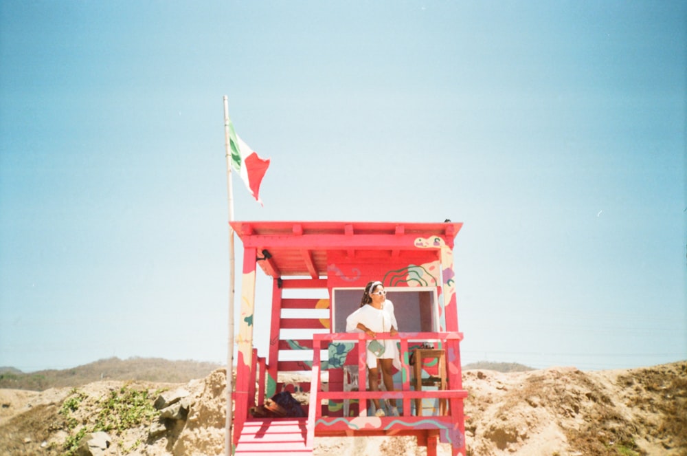 man in white t-shirt sitting on red wooden chair