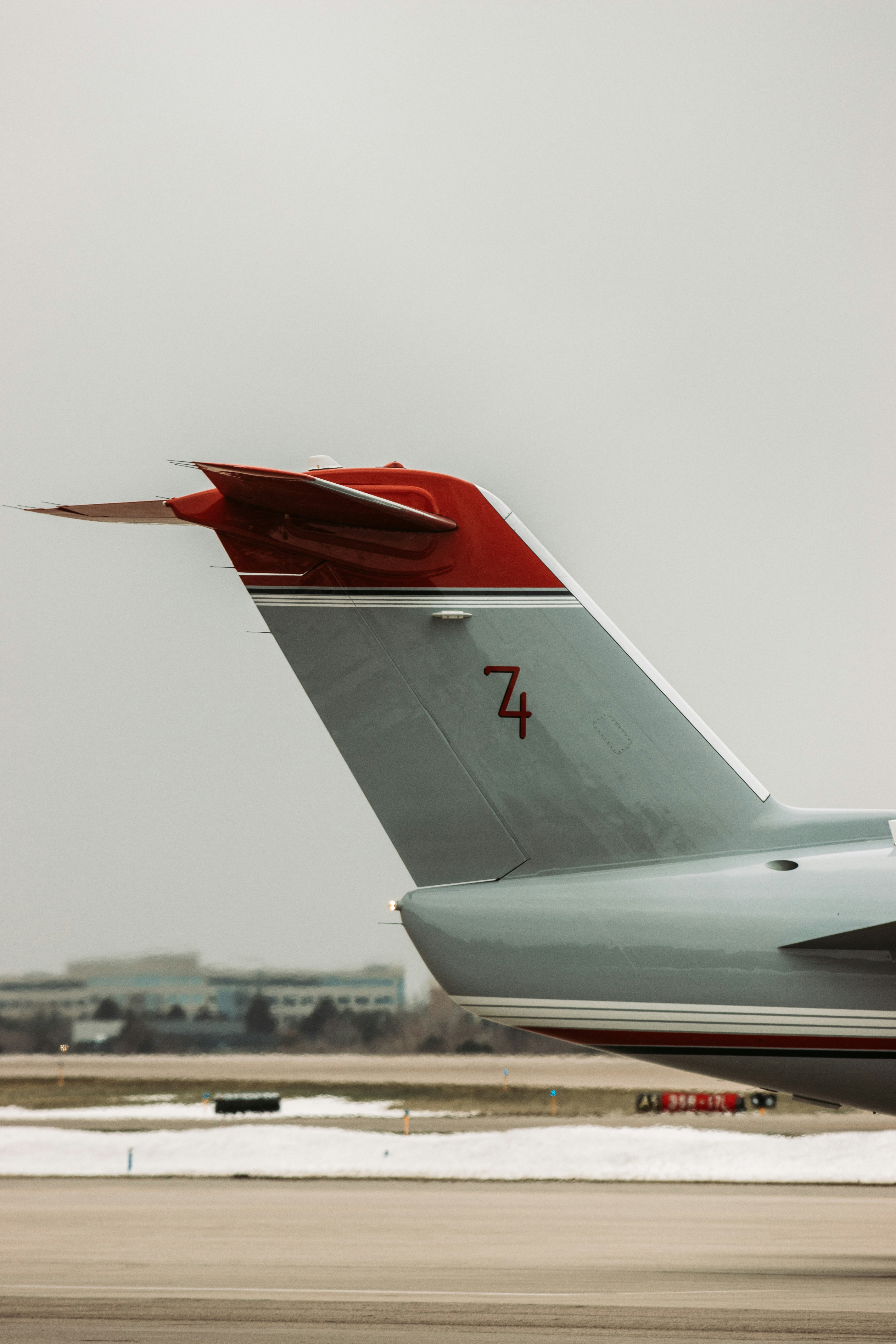 white and red airplane under white sky during daytime