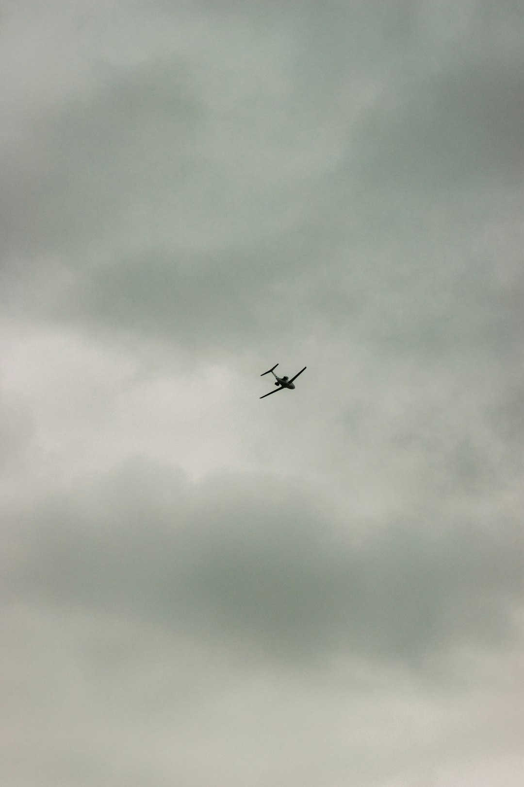 airplane in mid air under cloudy sky during daytime