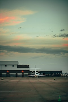 A private jet taxiing on a runway at sunset.