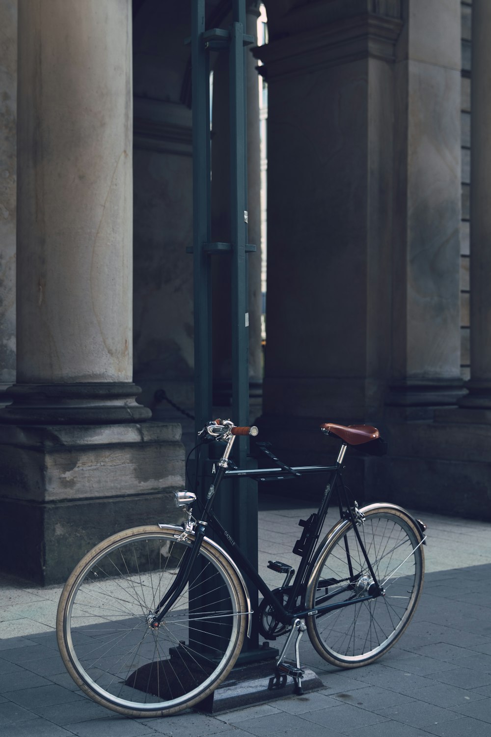 black city bike parked beside gray concrete building during daytime