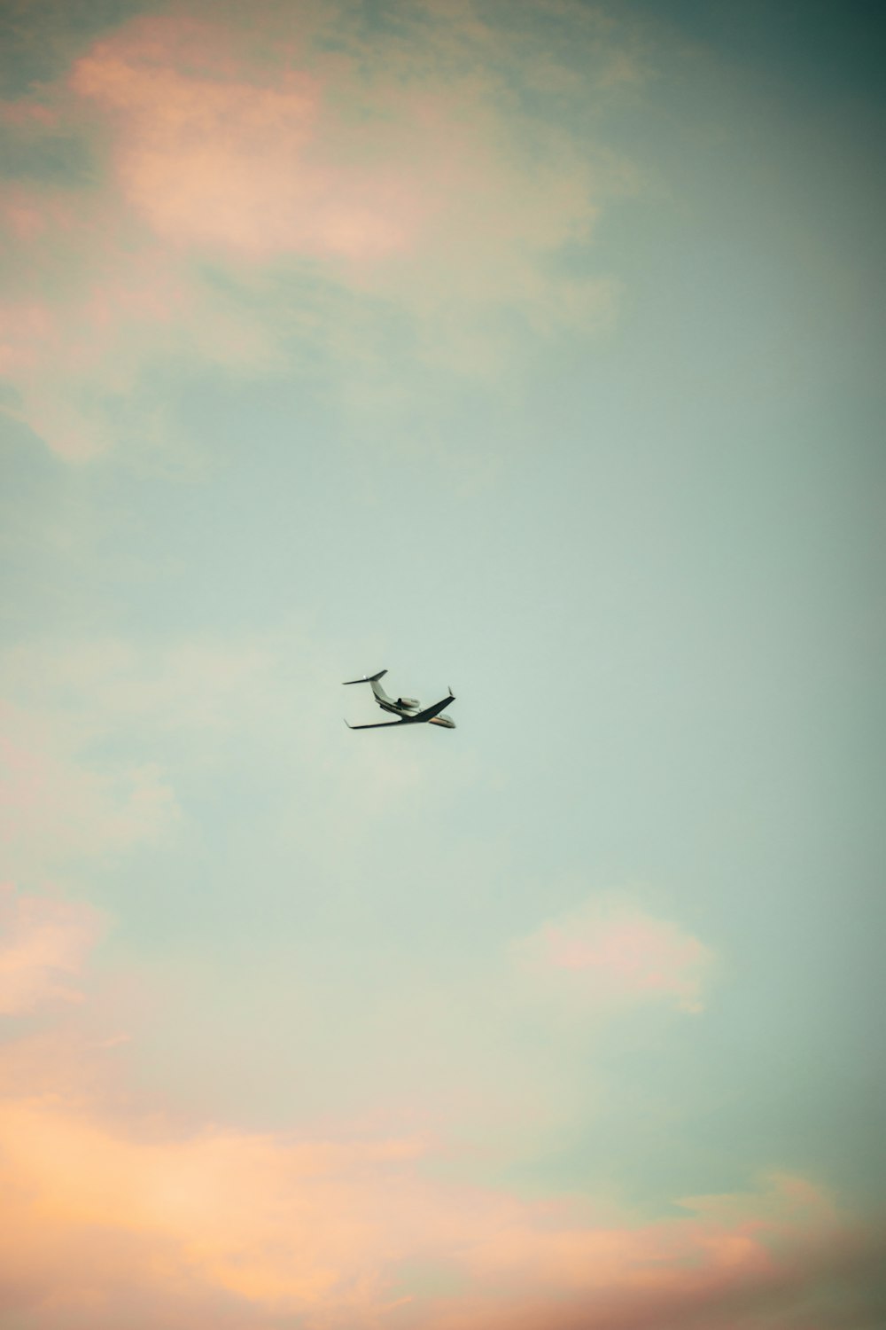 bird flying under white clouds during daytime