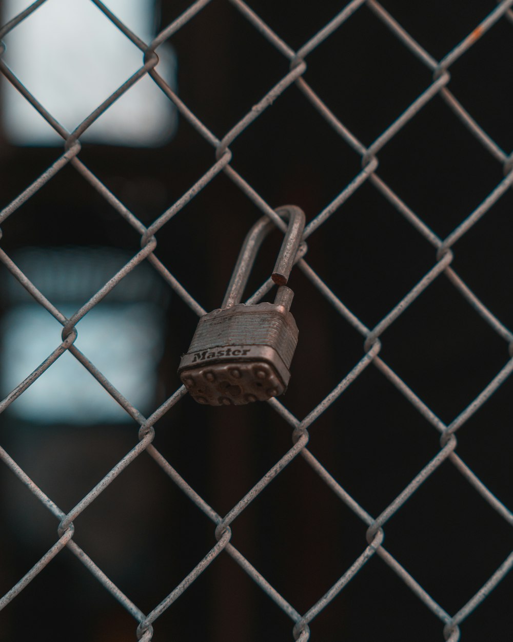 brass padlock on grey metal fence