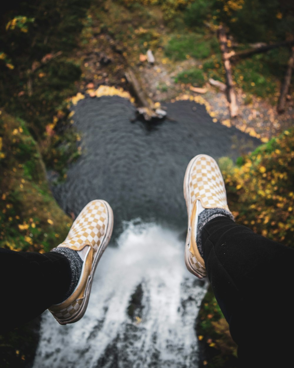 person in black pants and white sneakers