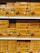 Shelves stacked with multiple boxes of 'de la Rosa' products, featuring a prominent rose logo and clear branding on yellow packaging.