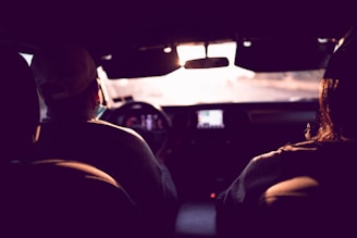 man in black jacket driving car during night time