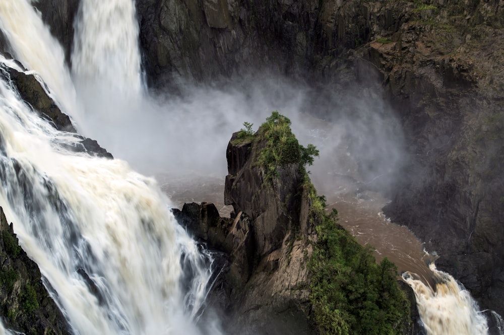 waterfalls on brown rocky mountain during daytime