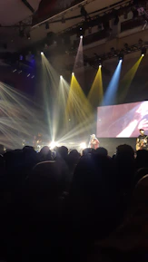 Artists performing live with colorful stage lights and energetic crowd.